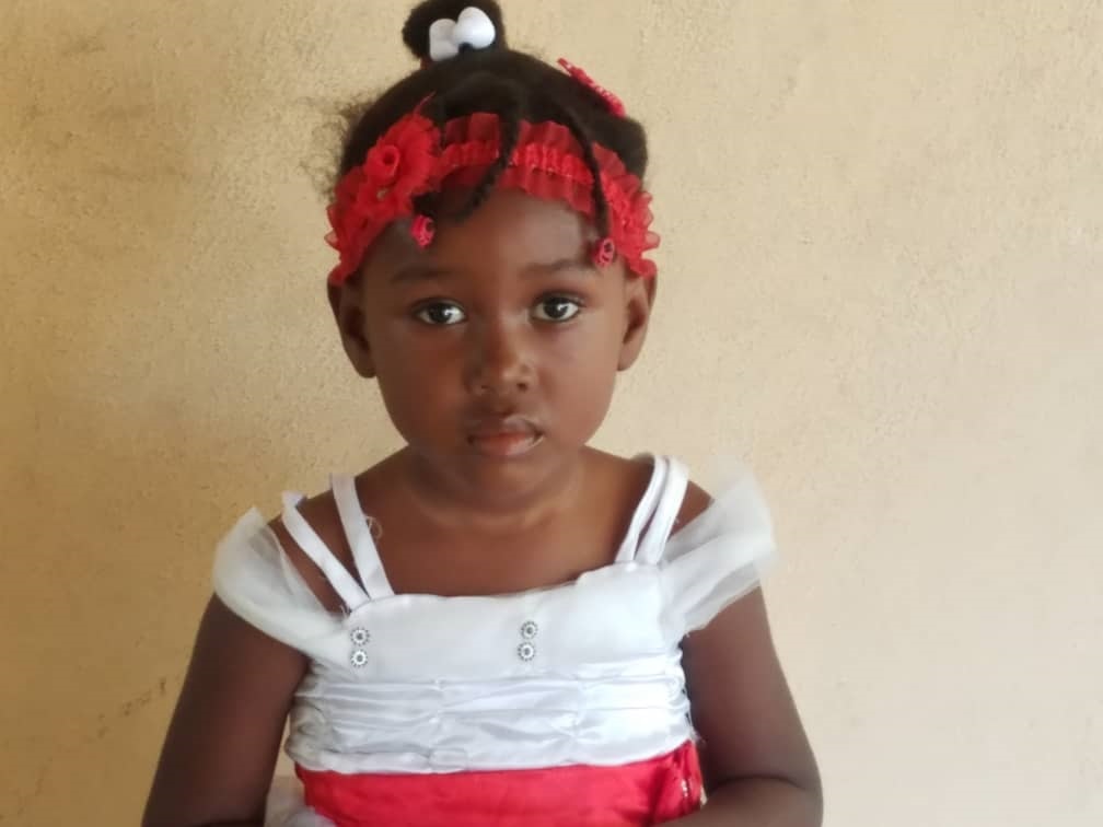 Portrait of a child wearing a red and white dress